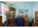 A home office featuring roll top wooden desk with decorations and a vintage curio cabinet with glass accessories at 19049 E Warren Dr # 105, Aurora, CO 80013