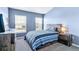 This bedroom boasts a blue accent wall, two windows, and wood furnishings at 9311 Amison Cir # 201, Parker, CO 80134