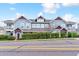 Charming townhome with blue siding, tasteful brick details, mature hedges, and a view from across the street at 9311 Amison Cir # 201, Parker, CO 80134