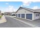 Row of attached garages with painted doors and gray siding at 9311 Amison Cir # 201, Parker, CO 80134
