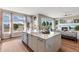 Open kitchen and living area with a large center island with seating and large windows with a view at 1658 Glade Gulch Rd, Castle Rock, CO 80104