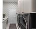 Well-organized laundry room with modern washer and dryer, ample storage, and decorative wallpaper at 1658 Glade Gulch Rd, Castle Rock, CO 80104