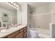 Well-lit bathroom with a sink, vanity, and shower over tub with white tile at 2209 S Flanders St, Aurora, CO 80013