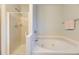 Bright bathroom featuring a glass shower and relaxing soaking tub with tile accents at 2209 S Flanders St, Aurora, CO 80013