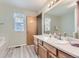 Bathroom with wood cabinets, bathtub and a large mirror at 2209 S Flanders St, Aurora, CO 80013