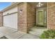 Close-up of the home's brick facade, including the garage, front door, and manicured landscaping at 2209 S Flanders St, Aurora, CO 80013