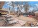 Spacious backyard featuring a patio area, gravel space with colorful chairs, and mature trees for shade at 16084 E Lehigh Cir, Aurora, CO 80013