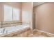 Bathroom featuring a soaking tub with decorative tile surround and separate shower stall at 16084 E Lehigh Cir, Aurora, CO 80013