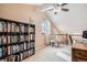 Cozy upstairs bedroom loft with a ceiling fan, a window, and a bookshelf at 16084 E Lehigh Cir, Aurora, CO 80013