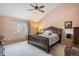 Spacious bedroom featuring a ceiling fan, large window, and decorative wooden bed frame at 16084 E Lehigh Cir, Aurora, CO 80013