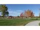 Scenic park view with walking path, picnic shelter, mature trees, and an expansive grassy field at 16084 E Lehigh Cir, Aurora, CO 80013