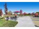 Community playground with various play structures, benches, and seating areas, set against a clear blue sky at 16084 E Lehigh Cir, Aurora, CO 80013