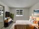 Virtually staged bedroom with a bed, dresser, and large window at 1723 Robb St # 31, Lakewood, CO 80215