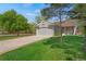 Inviting home with green lawn, mature trees, and a two-car garage, perfect for suburban living at 5566 S Zinnia St, Littleton, CO 80127