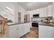 Modern kitchen with white cabinets, granite countertops, stainless steel appliances, and center island at 5566 S Zinnia St, Littleton, CO 80127