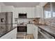 Well-appointed kitchen featuring white cabinets, granite countertops, and stainless steel appliances at 5566 S Zinnia St, Littleton, CO 80127