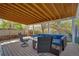 Comfortable covered patio area with wood flooring and cushioned outdoor seating at 5566 S Zinnia St, Littleton, CO 80127