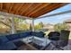 Spacious covered patio complete with outdoor furniture, a grill, and green backyard at 5566 S Zinnia St, Littleton, CO 80127