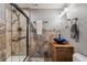 Bathroom featuring a glass shower, decorative tile accent wall, and a blue bowl sink at 18220 W 84Th Pl, Arvada, CO 80007