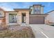 Charming two-story home featuring a stone-accented facade, covered entry, spacious driveway, and beautiful landscaping at 18220 W 84Th Pl, Arvada, CO 80007