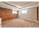Bedroom with neutral carpet, brick accent wall, and windows for natural light at 2607 E 14Th Ave, Denver, CO 80206