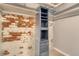 Bedroom with built-in shelving next to an exposed brick wall at 2607 E 14Th Ave, Denver, CO 80206