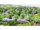 An aerial view of a leafy neighborhood featuring mature trees, well-maintained homes, and mountain views at 962 S Beech St, Lakewood, CO 80228