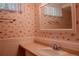 Small bathroom with seashell wallpaper, white trim and a bright white sink at 962 S Beech St, Lakewood, CO 80228