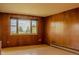 A light-filled bedroom features hardwood floors and wood paneled walls at 962 S Beech St, Lakewood, CO 80228