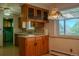Bright kitchen with wood cabinets, vintage lighting, and a sunlit window over the sink at 962 S Beech St, Lakewood, CO 80228