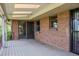 Covered wooden patio with brick siding, offering shade and outdoor living space at 962 S Beech St, Lakewood, CO 80228