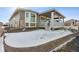 House exterior with covered porch and snow covered yard at 8885 S Tibet Ct, Aurora, CO 80016