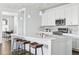 Modern kitchen with white cabinets, large island, and hardwood floors at 8885 S Tibet Ct, Aurora, CO 80016