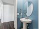 Modern powder room with a pedestal sink and blue walls at 8885 S Tibet Ct, Aurora, CO 80016