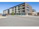 Contemporary mixed-use building with sleek design, multiple balconies, and street-level retail spaces at 2851 W 52Nd Ave # 208, Denver, CO 80221