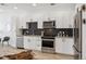 Modern kitchen with white cabinets, stainless steel appliances, and sleek black tile backsplash at 2851 W 52Nd Ave # 208, Denver, CO 80221