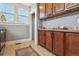 A Kitchen featuring wood cabinets, tile floor, gray walls, and natural light from the window at 3946 Perry St, Denver, CO 80212
