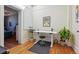 A modern home office featuring hardwood floors, skylight, a standing desk, and indoor plants at 3946 Perry St, Denver, CO 80212