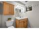 Traditional bathroom with a wood vanity, white fixtures, and bright lighting at 2250 S Zang Ct, Lakewood, CO 80228