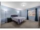 Comfortable bedroom with blue walls, neutral carpet, and ample natural light at 2250 S Zang Ct, Lakewood, CO 80228