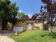 Charming two-story home with a well-manicured lawn, brick accents, and mature trees, showcasing curb appeal at 2250 S Zang Ct, Lakewood, CO 80228