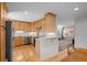 Bright kitchen with wood cabinets, stainless appliances, breakfast bar, and hardwood floors at 2250 S Zang Ct, Lakewood, CO 80228