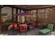 Cozy covered patio with a dining table, red cushioned chairs, and a chaise lounge at 2250 S Zang Ct, Lakewood, CO 80228