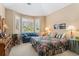 Cozy bedroom with a blue loveseat, large windows, and shutter blinds to filter in natural light at 8595 Gold Peak Dr # A, Highlands Ranch, CO 80130
