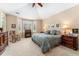 Spacious bedroom with large windows, ceiling fan, and furniture with ornate detailing at 8595 Gold Peak Dr # A, Highlands Ranch, CO 80130