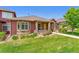 Charming exterior features a stone facade, lush landscaping, and a well-manicured lawn at 8595 Gold Peak Dr # A, Highlands Ranch, CO 80130