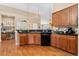 Open kitchen boasts wood cabinets, granite countertops, stainless steel dishwasher, and adjacent desk space at 8595 Gold Peak Dr # A, Highlands Ranch, CO 80130