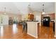 Open kitchen and dining area with hardwood floors, black appliances, and modern lighting at 8595 Gold Peak Dr # A, Highlands Ranch, CO 80130