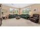 Bright living room with large windows, comfortable seating, and neutral carpeting at 8595 Gold Peak Dr # A, Highlands Ranch, CO 80130