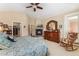 Inviting main bedroom boasts a fireplace, rocking chair, ceiling fan, and dresser with mirror at 8595 Gold Peak Dr # A, Highlands Ranch, CO 80130